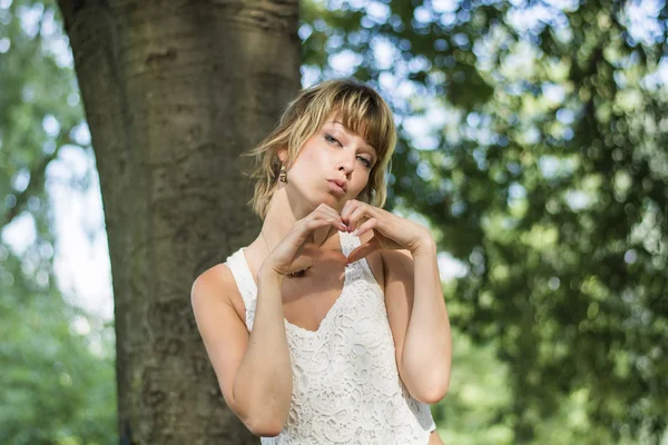 Young woman doing heart sign with hands — Stock Photo, Image
