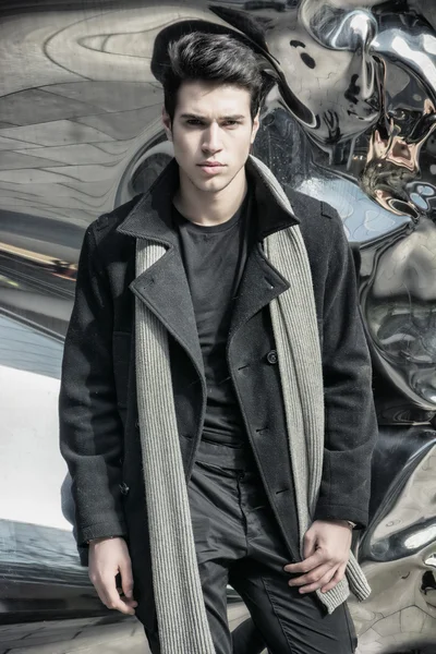 Красивый мужчина в черном пальто, стоя в городе — стоковое фото
