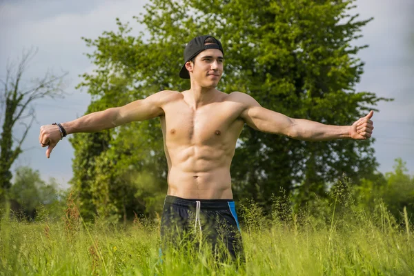 Shirtless young man doing funny pose standing — kuvapankkivalokuva