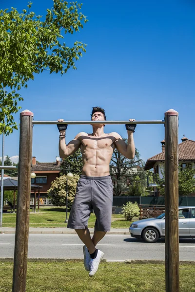 Jovem sem camisa atraente exercício ao ar livre no parque da cidade — Fotografia de Stock