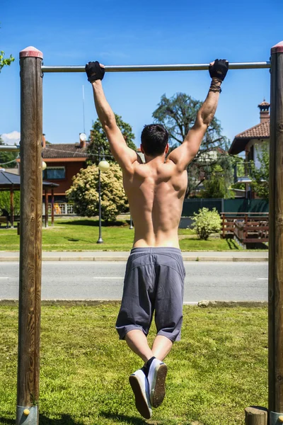 Aantrekkelijke shirtless jonge man buiten oefenen in stadspark — Stockfoto