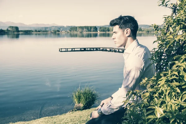 英俊的年轻男子，在阳光明媚的湖上 — 图库照片