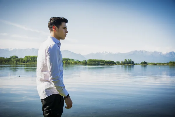 Uomo su un lago in una giornata soleggiata, tranquillo — Foto Stock