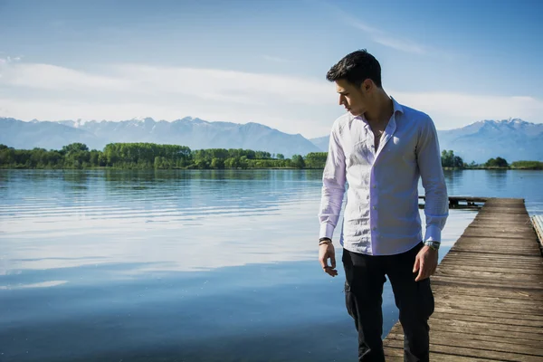 Aantrekkelijke jonge man op een meer in een zonnige — Stockfoto