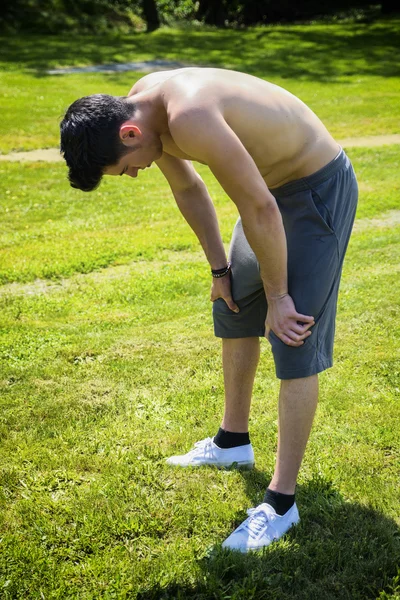 若い男が座っている、公園で休憩 — ストック写真