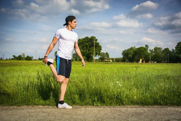 Young man outdoor in country doing stretching — Stock Photo, Image