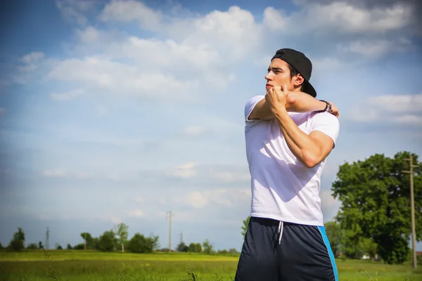 Young man outdoor in country doing stretching — Stock Photo, Image