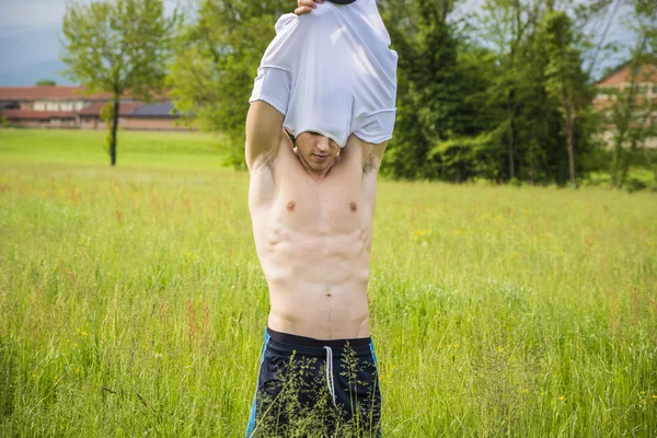 Young man at countryside, undressing — Stock Photo, Image