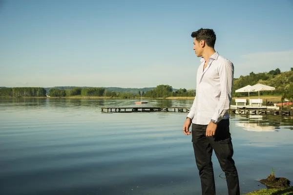 Atraktivní mladý muž na jezeře ve slunné — Stock fotografie