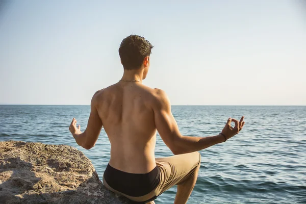 Young Man Meditating or Doing Yoga Exercise by Sea — Stock Photo, Image