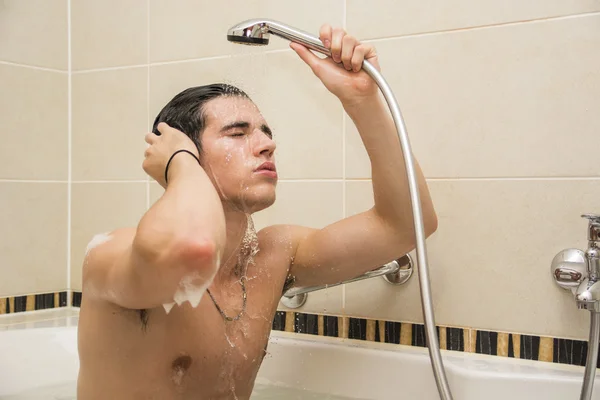 Handsome young man in bathtub at home having bath — Stock Photo, Image