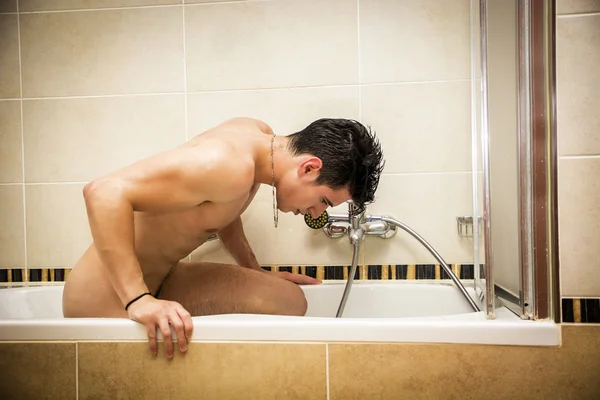 Bello giovane in vasca da bagno a casa facendo il bagno — Foto Stock