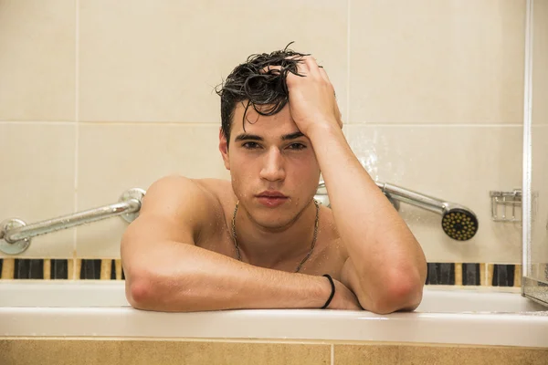 Beau jeune homme dans la baignoire à la maison ayant bain — Photo