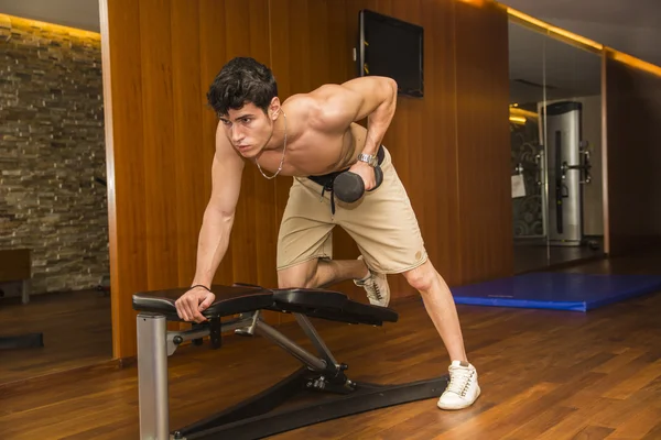 Muscular young male athlete working out in gym, exercising triceps — Stock Photo, Image