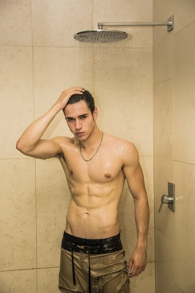 Aantrekkelijke jonge gespierde man nemen douche — Stockfoto