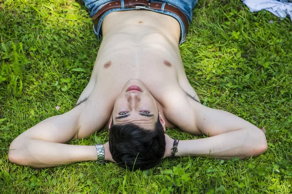 Shirtless ajuste modelo masculino relaxante deitado na grama — Fotografia de Stock