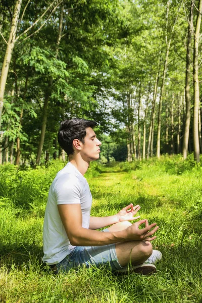 Junger Mann meditiert oder tun im freien Yoga-Übung — Stockfoto