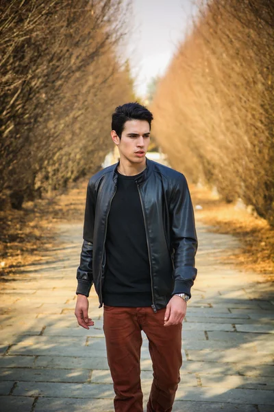 Handsome young man walking along rural road — Stock Photo, Image