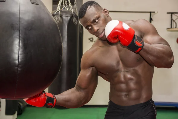 Africano macho boxer batendo bola com luvas de boxe — Fotografia de Stock