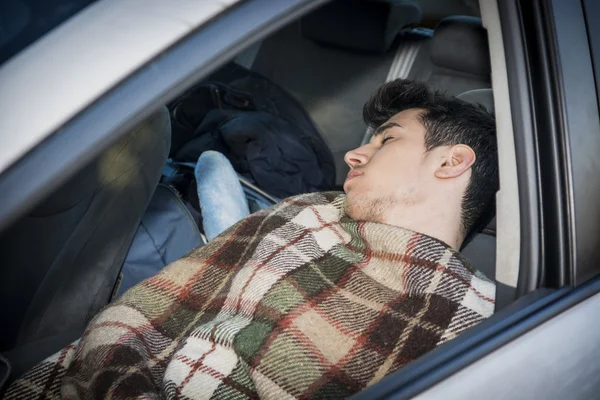 Jonge handosme man slapen in zijn auto — Stockfoto