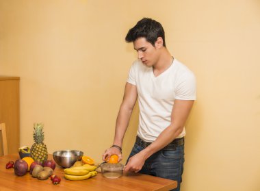 genç adam bir meyve salatası ya da iki yüzlü hazırlanıyor