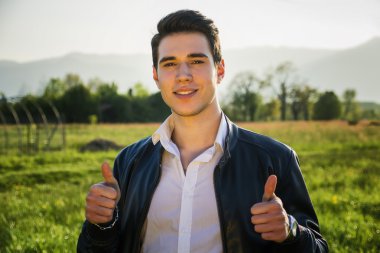 kırsal alan veya otlak önünde yakışıklı genç