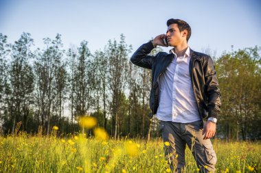 kırsal, yakışıklı genç adam cep telefonu kullanarak