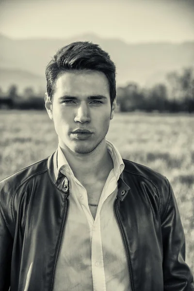 man at countryside, in front of field or grassland