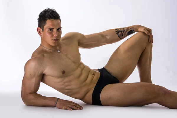 Handsome young bodybuilder laying down on floor — Stock Photo, Image