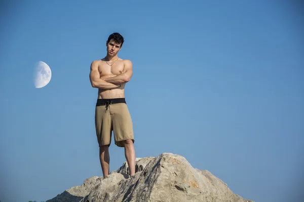 Muscular young man shirtless against the sky with moon — Stock Photo, Image