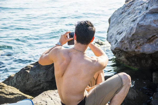 Torse nu jeune homme Prendre des photos à la plage — Photo