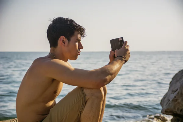 Torse nu jeune homme Prendre des photos à la plage — Photo