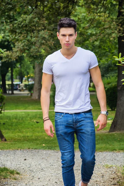 英俊的年轻男子，在白色 t 恤户外城市公园 — 图库照片