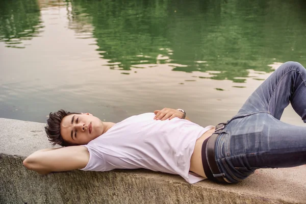 Handsome young man on a lakes shore or river banks — Stock Photo, Image