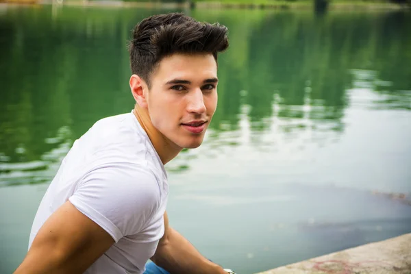 Handsome young man on a lakes shore or river banks — Stock Photo, Image