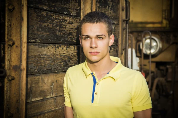 Handsome young man next to wood planks wall — Stok fotoğraf