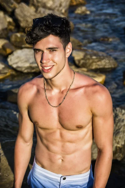 Muscular young man shirtless at sea — Stok fotoğraf