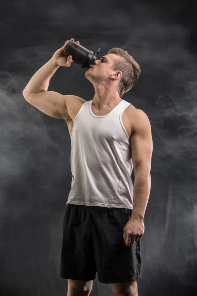 Attractive young man holding protein shake bottle. — Stock Photo, Image