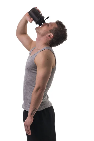 Attraktive junge Mann Betrieb Protein shake Flasche. isoliert — Stockfoto