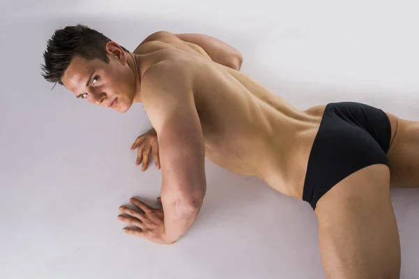 Stilig ung bodybuilder fastställande på golvet — Stockfoto