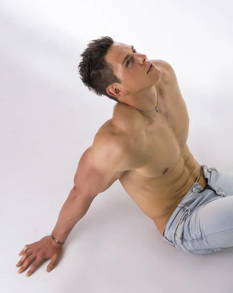 Handsome young bodybuilder laying down on the floor — kuvapankkivalokuva