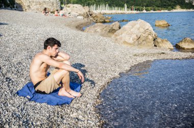 Handsome young man on beach in a sunny day