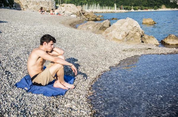 Handsome young man on beach in a sunny day — Fotografia de Stock