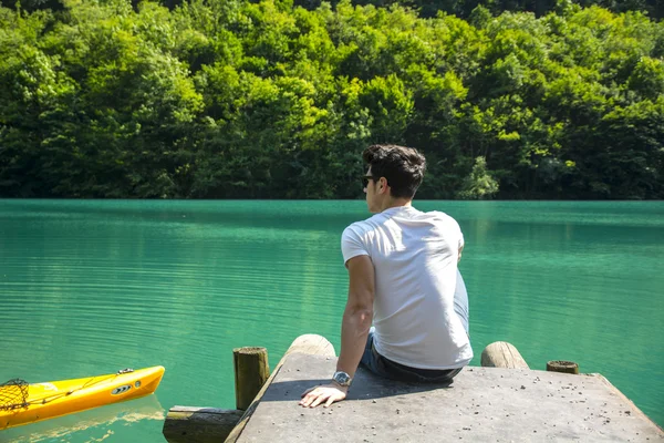 Güneşli, huzurlu bir gün bir göl üzerinde yakışıklı genç — Stok fotoğraf