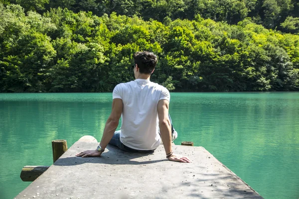 Bel giovanotto su un lago in una giornata di sole e pace — Foto Stock