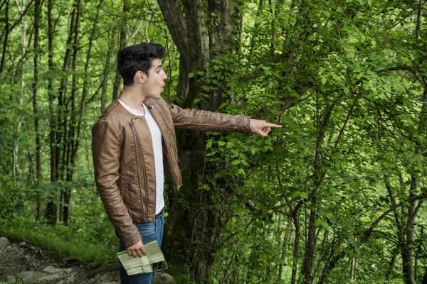 Excited Young Man with Map Pointing into Forest — Stock Photo, Image