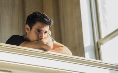 Young Man Resting with Head on Staircase Railing