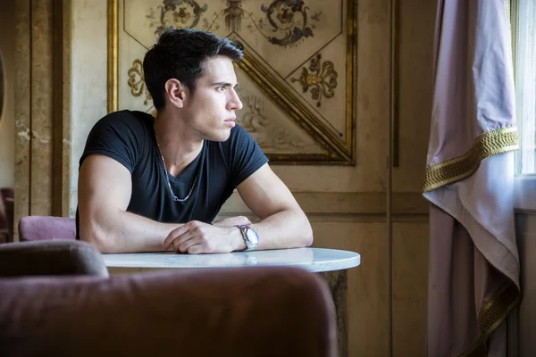 Relaxed Young Man Sitting Comfortably at Table — 图库照片