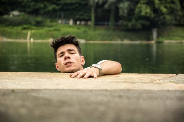 Young man desperate to save himself from falling