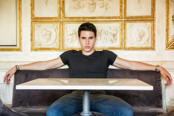 Sitzen entspannte junge Mann, der bequem am Tisch — Stockfoto